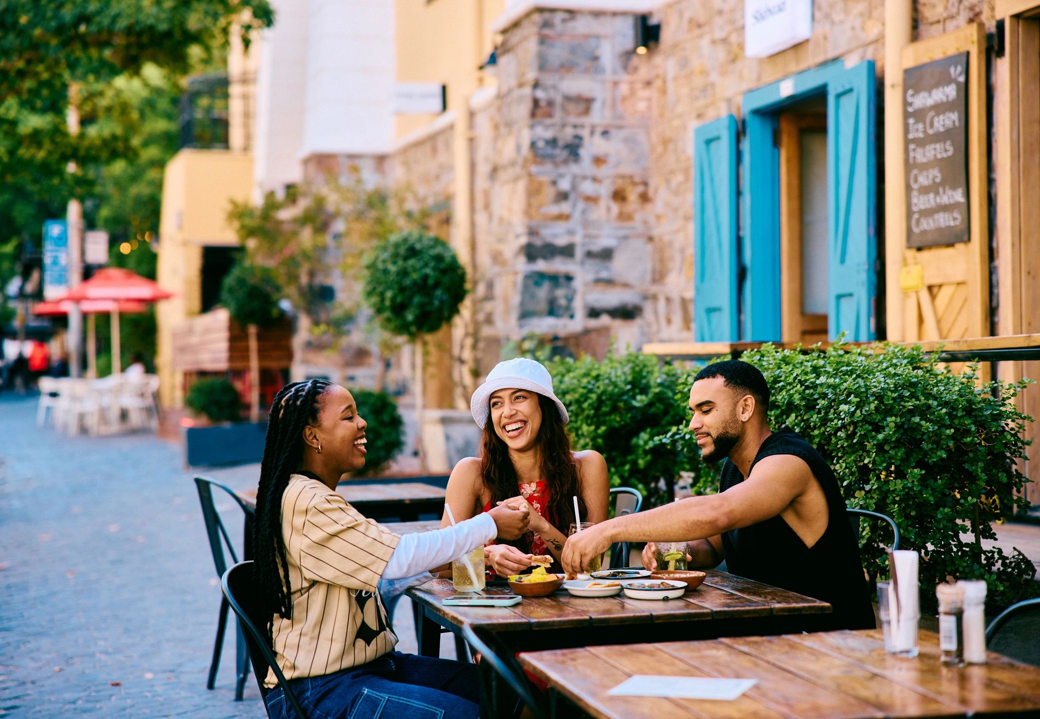 Friends sharing food and drinks at a café table